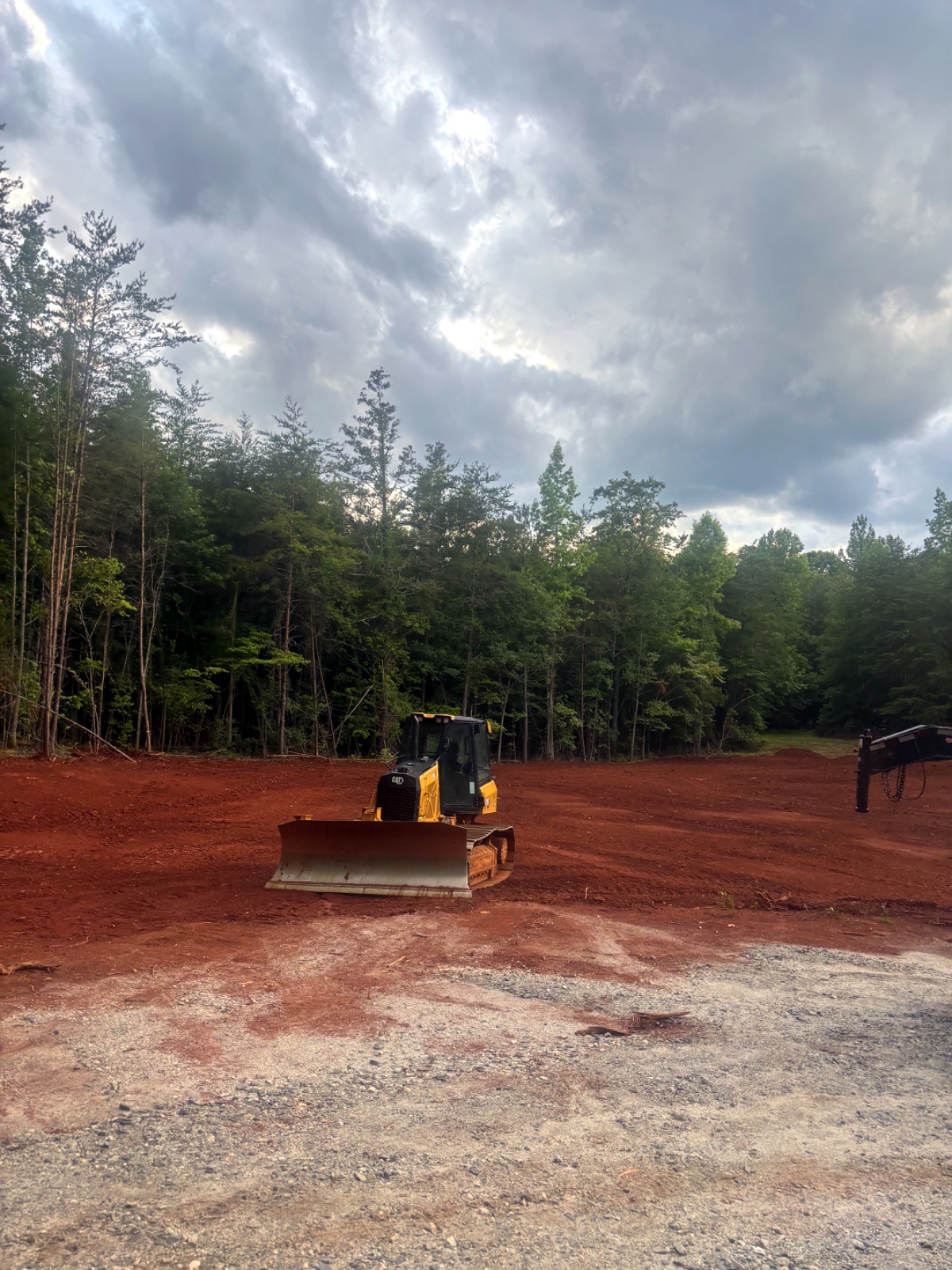 CAT dozer grading a red-clay building pad