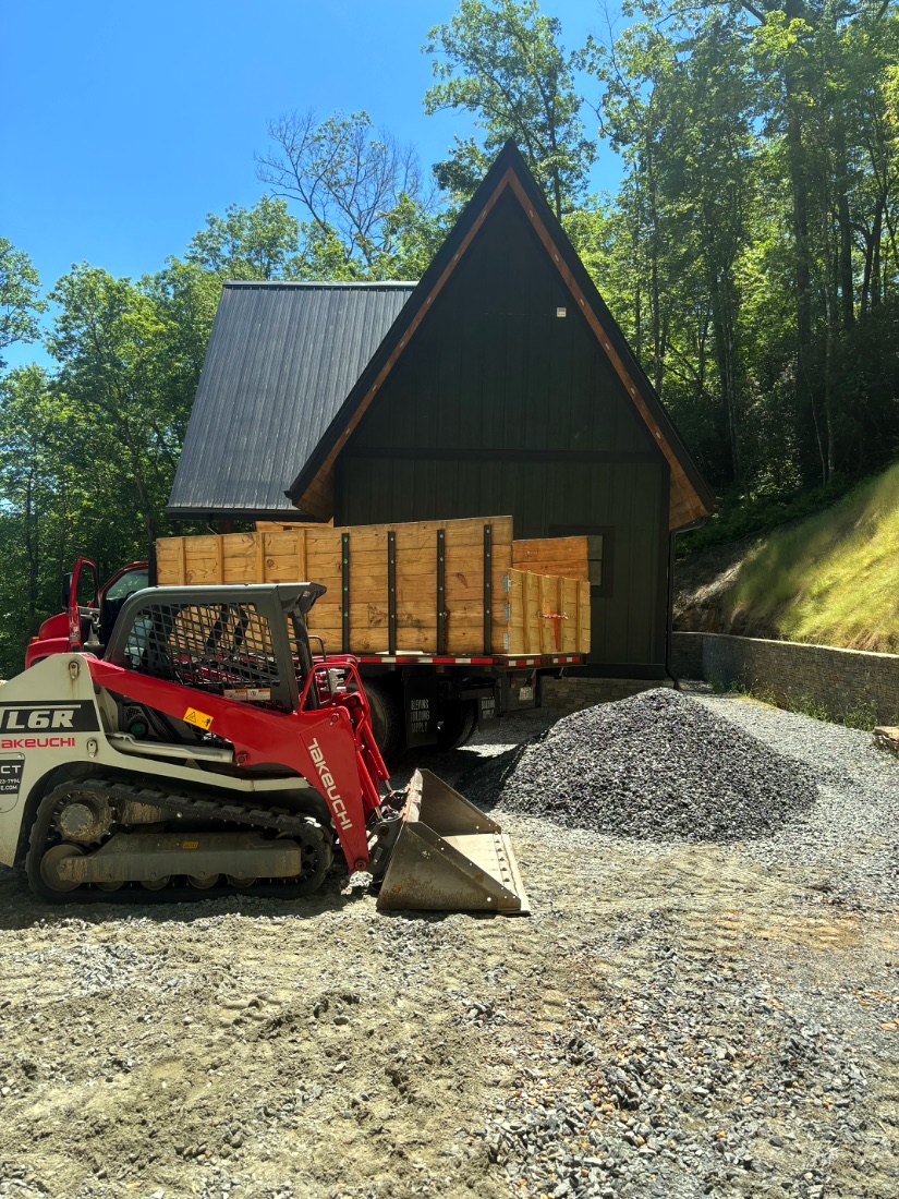 Skid steer moving timber and gravel at a Western North Carolina build site